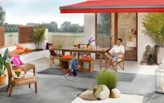 Rote Reflexa Gelenkarmmarkise aeria über Terrasse