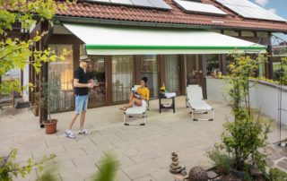 Reflexa Gelenkarmmarkise Benita über Terrasse montiert